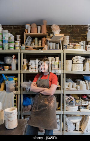 Caucasian woman standing in pottery workshop Stock Photo