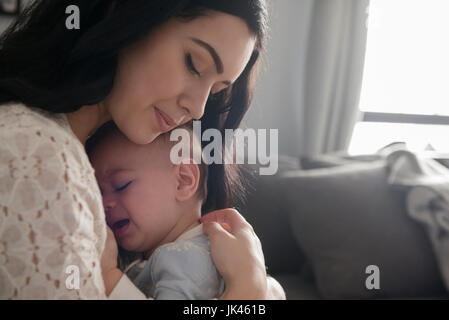 Caucasian mother comforting crying baby son Stock Photo