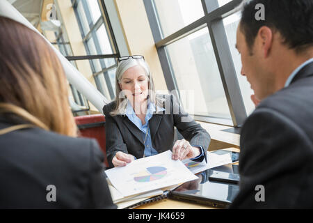 Business people examining chart in meeting Stock Photo