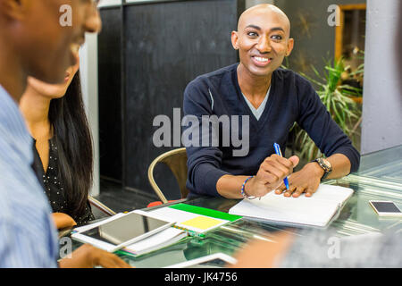 Smiling man with notebook in meeting Stock Photo