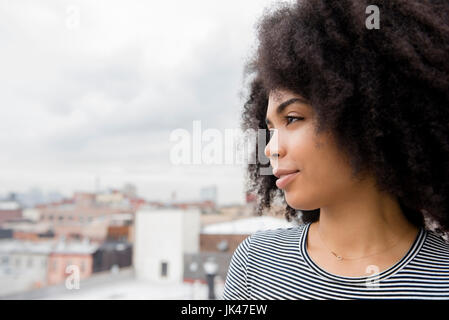 African American woman smiling on rooftop Stock Photo