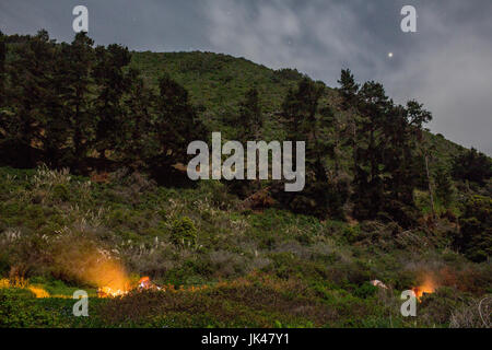 Campfire on hill at night Stock Photo