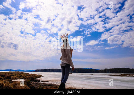 Caucasian woman wearing headdress near river Stock Photo