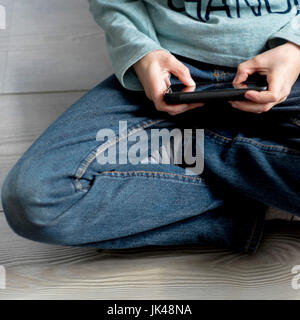 Close up of Caucasian boy playing with cell phone Stock Photo