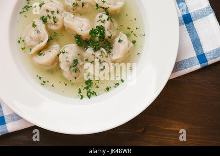 Dumplings in bowl of soup Stock Photo