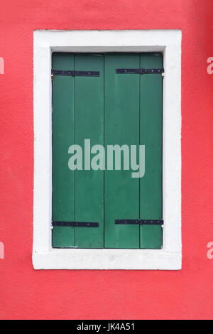 Closed green retro window shutters on red facade Stock Photo