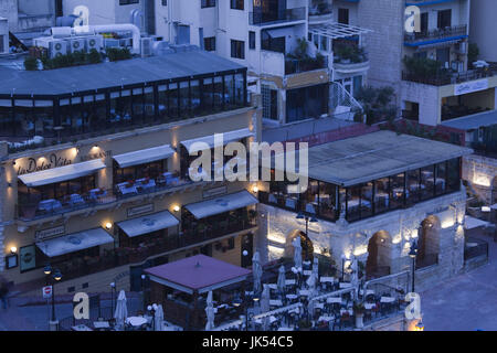 Malta, Valletta, St. Julian's, cafes on Spinola Bay, high angle view, evening Stock Photo