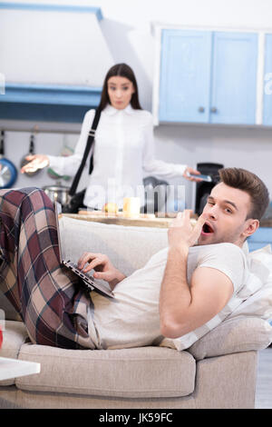 Young working woman resented by her lazy husband. Stock Photo