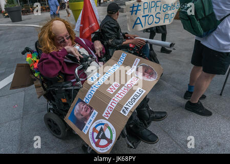 July 21, 2017 - London, UK - London, UK. 21st July 2017. A wheelchair user with a poster at the DPAC (Disabled People Against Cuts) protest at the London HQ of Atos who carry out PIP (Personal Independence Payment) assessments for the Dept of Work and Pensions. Though Atos lost the contract for Work Capability Assessment they are still assessing the needs of the disabled for PIP, using inadequately trained and qualified staff to produce assessments that DPAC say a ''riddled with lies and inaccuracies.'' They say assessments should be carried out by suitably medically qualified staff and that t Stock Photo