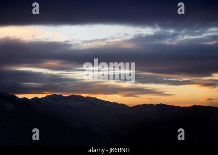 Sunrise coming over a mountain with clouds. Stock Photo