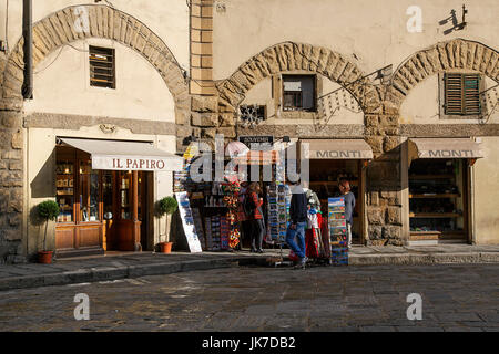 Florence, Italy: November 20, 2016: Tourists browse the souvenir shops near the Duomo Santa Maria Del Fiore in Florence. They are looking at postcards Stock Photo