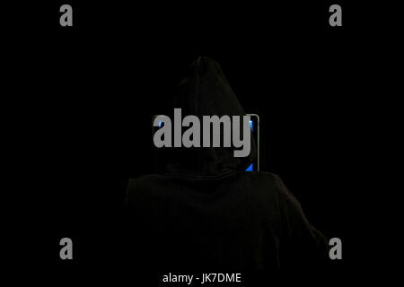 Anonymous hacker behind a laptop working in the dark, clandestine and digital world of hacking, cybersecurity, cyber attack, cybercrime concept Stock Photo