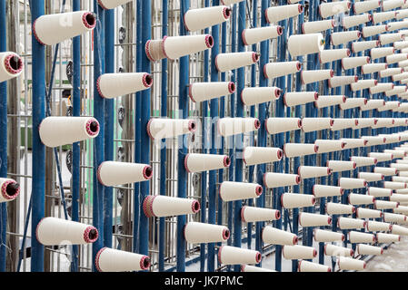 large group of bobbin thread cones on a warping machine in a textile ...