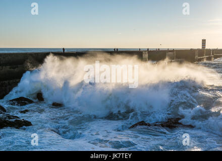 Atlantic Ocean wave crashing on rocks and breakwater in Foz do Douro district of Porto city, second largest city in Portugal Stock Photo