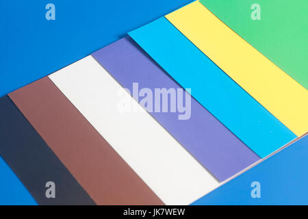 Colourful paper sheets on blue background Stock Photo