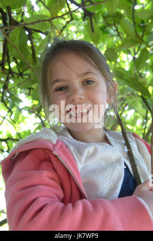 girl climbing tree in pub garden Stock Photo