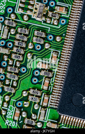 Surface mount technology (SMT) components on a green printed circuit board. Interconnected concept. Wiring inside computer, circuit close up. Stock Photo