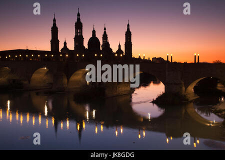 Spain, Aragon Region, Zaragoza Province, Zaragoza, Basilica de Nuestra Senora de Pilar and the Puente de Piedra bridge, on the Ebro River, dusk Stock Photo