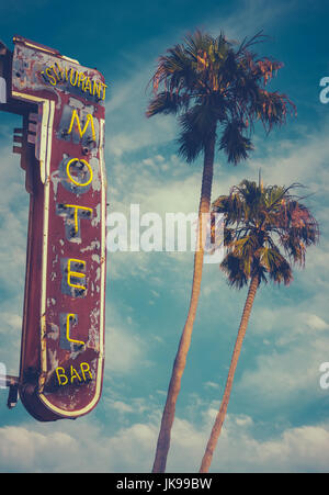 Retro Worn Vintage Neon Motel Sign And Palm Trees Stock Photo