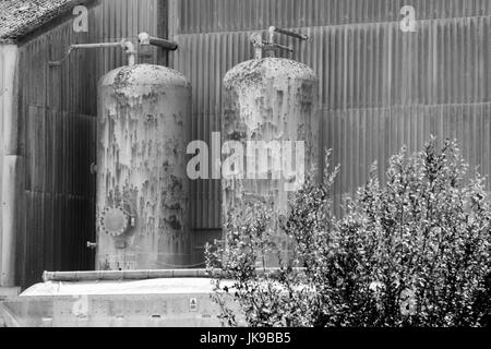 Black and white image of two external high pressure cylinders involved in a manufacturing process. Stock Photo