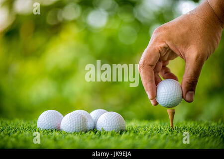 golf players hand placing ball on grass Stock Photo