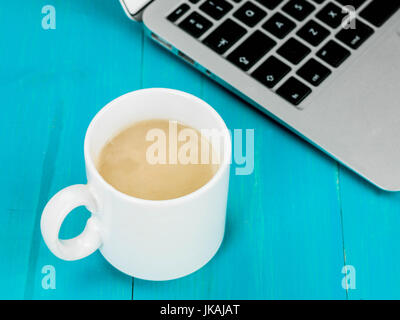 Cup of Mushroom Soup With a Laptop Computer Against a Blue Wooden Background Stock Photo