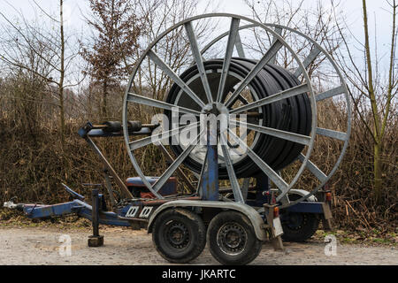 Steel roller with fiber optic cables for the installation of data cables on a construction site. Stock Photo