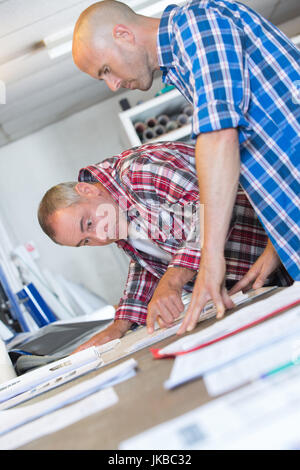 two architects discussing details of blueprint Stock Photo