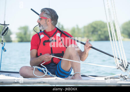 handsome mature man sailing on hobby catamaran Stock Photo