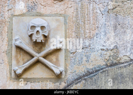 Skull and Cross Bones on Stone Wall with Copy Space Stock Photo