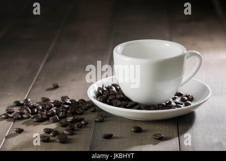 white cup of coffee on brown wood table, dark tone Stock Photo