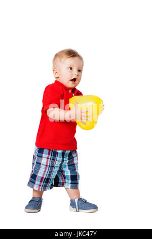 baby boy standing on the floor with a yellow balloon Stock Photo