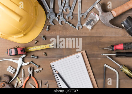 blank notebook and tools supplies on wood background top view. construction industry flat lay concept Stock Photo