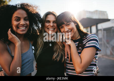 Outdoor shot of three young women having fun on city street. Multiracial female friends enjoying a day around the city.