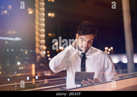 Airport lounge. Businessman inside the airport terminal using digital tablet. Handsome male executive waiting at airport lounge with tablet pc. Stock Photo