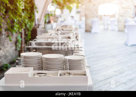 Buffet heated trays standing in line ready for service. Outdoors buffet restaurant, the hotel restaurant. Stock Photo