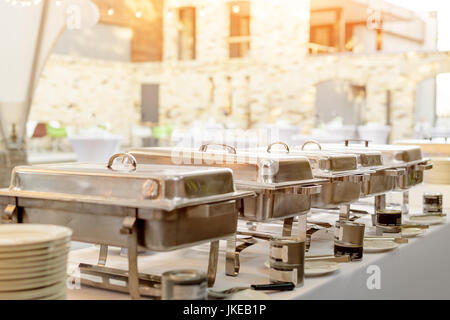 Buffet heated trays standing in line ready for service. Outdoors buffet restaurant, the hotel restaurant. Stock Photo