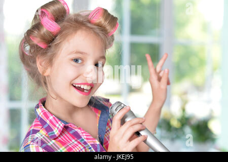 Portrait of adorable little girl singing karaoke Stock Photo