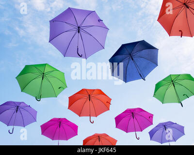 Weather concept. Umbrellas over blue sky with clouds.Seen from below. Stock Photo