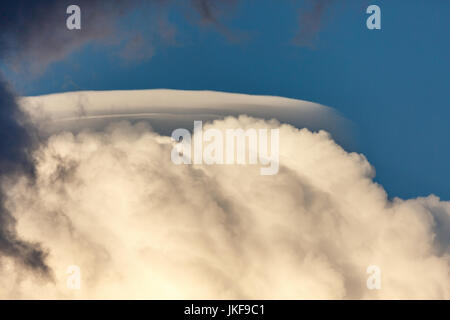 Rare Lenticular cloud (Altocumulus lenticularis) on top of a cumulus cloud infront of a blue sky in Wisconsin on a warm day in July Stock Photo