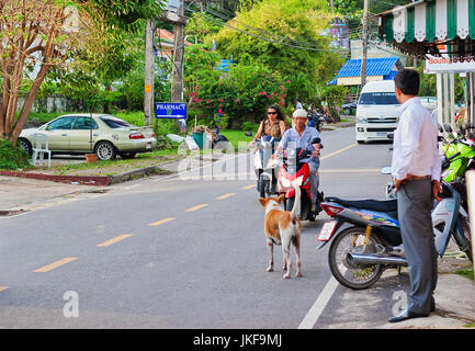 PHUKET ISLAND, THAILAND - OCTOBER 12, 2009: Man and woman rides on a scooter through the streets on Surin beach in Phuket Stock Photo