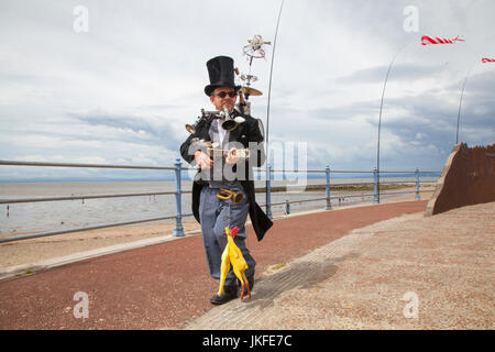 Have A Banana One Man Band One Man Bands from across the country converge on Morecambe Promenade for a fun free festival of musical mayhem.  The one-man band with art deco top hat has a special place in everyone’s imagination and this celebration of co-ordination is a unique event and that catches the imagination of people, whatever their age. Once seen never forgotten. Bands come in all shapes and sizes, play music from every genre. Stock Photo