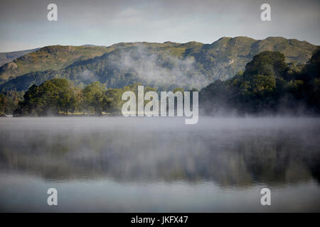 Morning mist over Windermere a large lake in Cumbria’s Lake District National Park,  land the largest natural lake in England Stock Photo