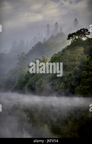 Morning mist over Windermere a large lake in Cumbria’s Lake District National Park,  land the largest natural lake in England Stock Photo