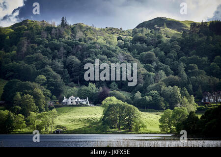 Landscape featuring rolling hills, trees and the sun breaking through the clouds Stock Photo