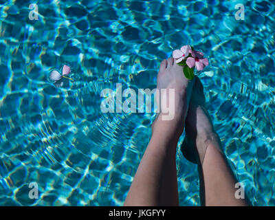 POV Young Lady with feet in water flower between toes Stock Photo