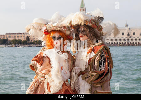 Venice Carnival  2017, Venice, Veneto, Italy.  Couple in classical costumes posing on San Giorgio Maggiore with the lagoon and Doges Palace behind Stock Photo