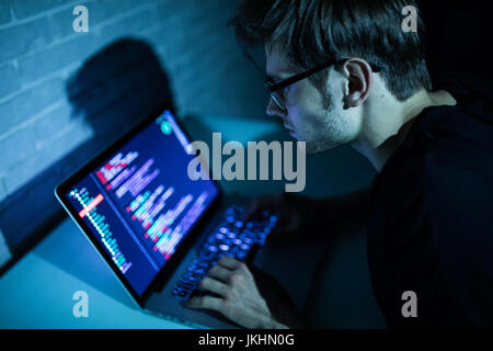 Hacker man trying to breach security of a computer system search internet. Hacker Stock Photo