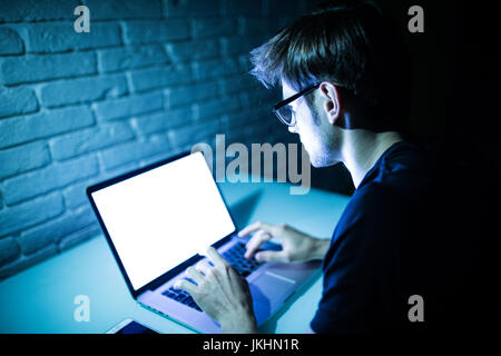 Man using laptop writing programming code on laptop Stock Photo