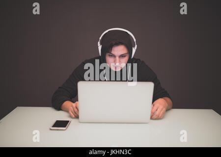 Man Hacker working on a laptop on table . Hacker Stock Photo